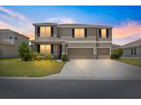 Two-story home featuring a three-car garage, well-manicured lawn and professional landscaping at 8142 Sw 59Th Ave, Ocala, FL 34476