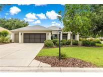 Charming single Gathering home with a well maintained lawn, mature tree, and a two-car garage at 8961 Se 130Th Loop, Summerfield, FL 34491