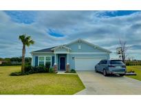 Charming single-story home with a well-manicured lawn, a two-car garage, and stylish light blue siding at 9253 Sw 58Th Cir, Ocala, FL 34476