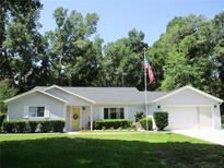 Charming single-story home with a manicured lawn, attached garage, and an inviting yellow front door at 14192 Sw 112Th Cir, Dunnellon, FL 34432