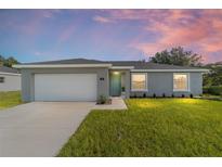 Charming single-story home with a well-manicured lawn, attached garage, and inviting front entrance at 14863 Sw 60Th Ter, Ocala, FL 34473