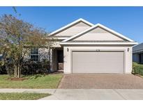 Charming single-story home featuring a two-car garage and manicured front lawn with a brick-paved driveway at 3947 Nw 46Th Ter, Ocala, FL 34482