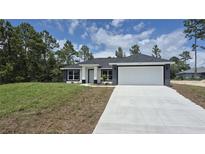 Charming single-story home with a two-car garage and well-maintained lawn at 717 Marion Oaks Mnr, Ocala, FL 34473