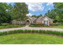 Charming stone front home with a circular driveway and lush landscaping at 7915 Se 12Th Cir, Ocala, FL 34480