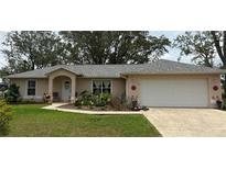 Charming single-story home with a well-maintained lawn and colorful flower beds, offering delightful curb appeal at 106 Pine Trce, Ocala, FL 34472