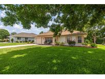 Charming single story home with a well-manicured lawn, brick driveway, and cozy front porch at 11326 Se 175Th Pl, Summerfield, FL 34491