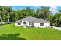 Beautiful one story home with a spacious front yard, well manicured landscaping, and a gray roof at 130 Nw 113Th Cir, Ocala, FL 34482
