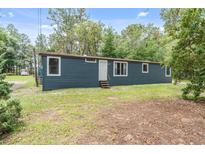 Charming single-story home featuring blue siding, a manicured lawn, and a welcoming front entrance at 16082 Sw 24Th Pl, Ocala, FL 34481