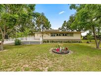Charming home featuring mature landscaping, a flamingo water feature, and inviting deck at 22535 Sw 117Th St, Dunnellon, FL 34431