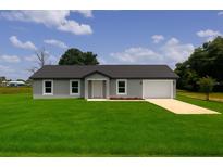 Charming single-story home with a well-maintained lawn, attached garage and classic curb appeal under a sunny sky at 3527 Sw 149Th Ter, Ocala, FL 34481