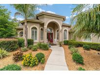 Stunning single-story home featuring a charming red door, lush landscaping, and inviting curb appeal at 3986 Se 43Rd Cir, Ocala, FL 34480