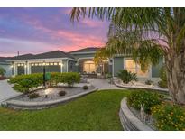 Charming single-story home with a three-car garage, well-manicured landscaping, and a paver walkway leading to the front entrance at 488 Seth Run, The Villages, FL 32163