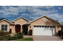 Charming single-story home with brick driveway, manicured landscaping, and an attached two-car garage at 8781 Sw 82Nd Court Rd, Ocala, FL 34481