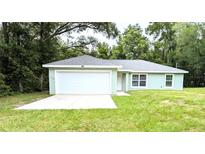 Charming single-story home with a two-car garage, lush lawn, and welcoming curb appeal at 13921 Sw 108Th Ln, Dunnellon, FL 34432
