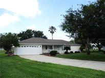 Charming single-story home with a well-maintained lawn, lush landscaping, and a paved driveway at 14695 Sw 112Th Cir, Dunnellon, FL 34432