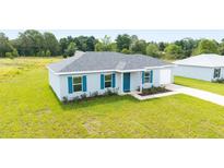 Charming single-story home with a well-manicured lawn, blue shutters, and an attached one-car garage at 14698 Sw 20Th Pl, Ocala, FL 34481