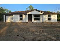 Newly constructed single-story home featuring white exterior, brown trim, and an attached garage at 20 Malauka Trail Crse, Ocklawaha, FL 32179