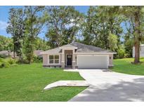 Charming single-story home boasts a two-car garage and a well-manicured lawn at 3696 Se 139Th Ln, Summerfield, FL 34491