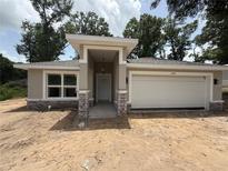 Charming single-story home with an attached garage and covered entryway in a suburban setting at 3696 Se 139Th Ln, Summerfield, FL 34491
