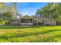 Charming single-story home with mature trees, screened porch, and well-maintained lawn at 4609 Ne 7Th St, Ocala, FL 34470
