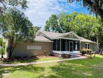 Charming single-story home featuring a screened porch, landscaped front yard, and a brick walkway at 4609 Ne 7Th St, Ocala, FL 34470