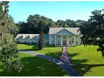 A stately home with a manicured lawn and tree lined drive at 5765 Nw 110Th St, Ocala, FL 34482
