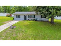Charming single-story home with a well-maintained front yard and a concrete driveway at 6511 Se 25Th Ave, Ocala, FL 34480
