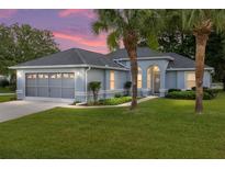 Charming single story home featuring well-maintained landscaping, blue paint, and a two car garage at 11051 Sw 73Rd Ct, Ocala, FL 34476