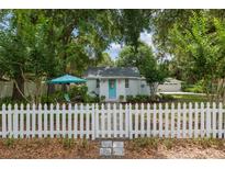 Charming home featuring a well-manicured lawn and inviting white picket fence at 12335 Se 130Th Ct, Ocklawaha, FL 32179