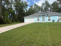 Charming single-story home with a well-manicured lawn, solar panels, and a long driveway at 13155 Sw 73 Ave, Ocala, FL 34473