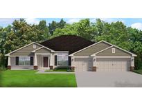 Charming single-story home featuring a manicured lawn, attached three car garage and welcoming front entryway at 13977 Sw 81St St, Dunnellon, FL 34432