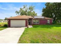 Charming single-story home with a well-manicured lawn, attached garage, and inviting front entrance at 32 Dogwood Drive Loop, Ocala, FL 34472