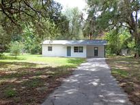 Charming single-story home with a long driveway and well-maintained lawn surrounded by lush greenery at 3418 Se 94Th St, Ocala, FL 34480