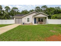 Charming single-story home with a well-manicured lawn and inviting front porch at 5063 Se 168Th Ter, Ocklawaha, FL 32179