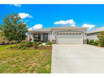 Charming single-Gathering home features a manicured lawn, stone accents, and a two-car garage at 7891 Sw 89Th Cir, Ocala, FL 34481