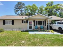Charming single-story home with a covered porch, car port and well-maintained lawn at 8368 Sw 105Th Pl, Ocala, FL 34481
