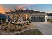Charming single-story home featuring a landscaped front yard, covered porch, and a two-car garage with decorative windows at 8878 Sw 103Rd Cir, Ocala, FL 34481