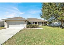 Charming single-story home with a well-maintained lawn and attached two-car garage at 9952 Sw 58Th Ave, Ocala, FL 34476