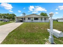 Charming single-story home featuring a well-maintained lawn, carport, and inviting white picket fence at 10210 Sw 93Rd Ave, Ocala, FL 34481