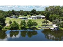 Expansive lakefront property featuring a main house, guest house, private dock and lush landscaping at 10893 Se 141 Avenue Rd, Ocklawaha, FL 32179