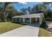 Charming single-story home features a driveway, covered carport, and well-maintained lawn at 17009 Se 60Th St, Ocklawaha, FL 32179