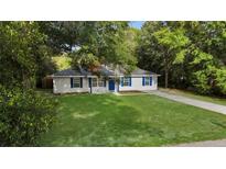 Charming one-story home with a well-manicured lawn, blue shutters, and mature trees at 2263 Moines Ct, Dunnellon, FL 34431