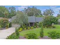 Charming home featuring lush landscaping, mature trees, and a well-manicured lawn at 2441 Se 38Th St, Ocala, FL 34480