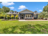 Charming single-story home with a well-manicured lawn, mature trees, and inviting front porch at 300 Se Highway 42, Summerfield, FL 34491