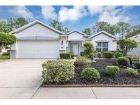 Charming one-story home featuring a manicured front yard with lush landscaping and a two-car garage at 5151 Sw 39Th St, Ocala, FL 34474