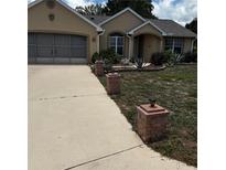 Charming one-story home featuring a well-manicured lawn and decorative brick pillars at 7802 Sw 114Th Loop, Ocala, FL 34476