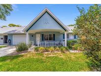 Charming single-story home with a covered front porch, well-manicured lawn, and attached garage at 8431 Sw 93Rd Pl # F, Ocala, FL 34481