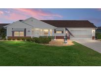 Charming home featuring a well-manicured lawn, attractive landscaping, and an inviting front porch at 8554 Sw 63Rd Ct, Ocala, FL 34476