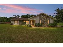Charming single-story home featuring a stone facade and well-maintained landscaping at 9420 Ne 12Th Ct, Ocala, FL 34479