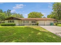 Charming single-story home featuring a well-maintained lawn and attached two-car garage at 12178 Palmetto Way, Dunnellon, FL 34432